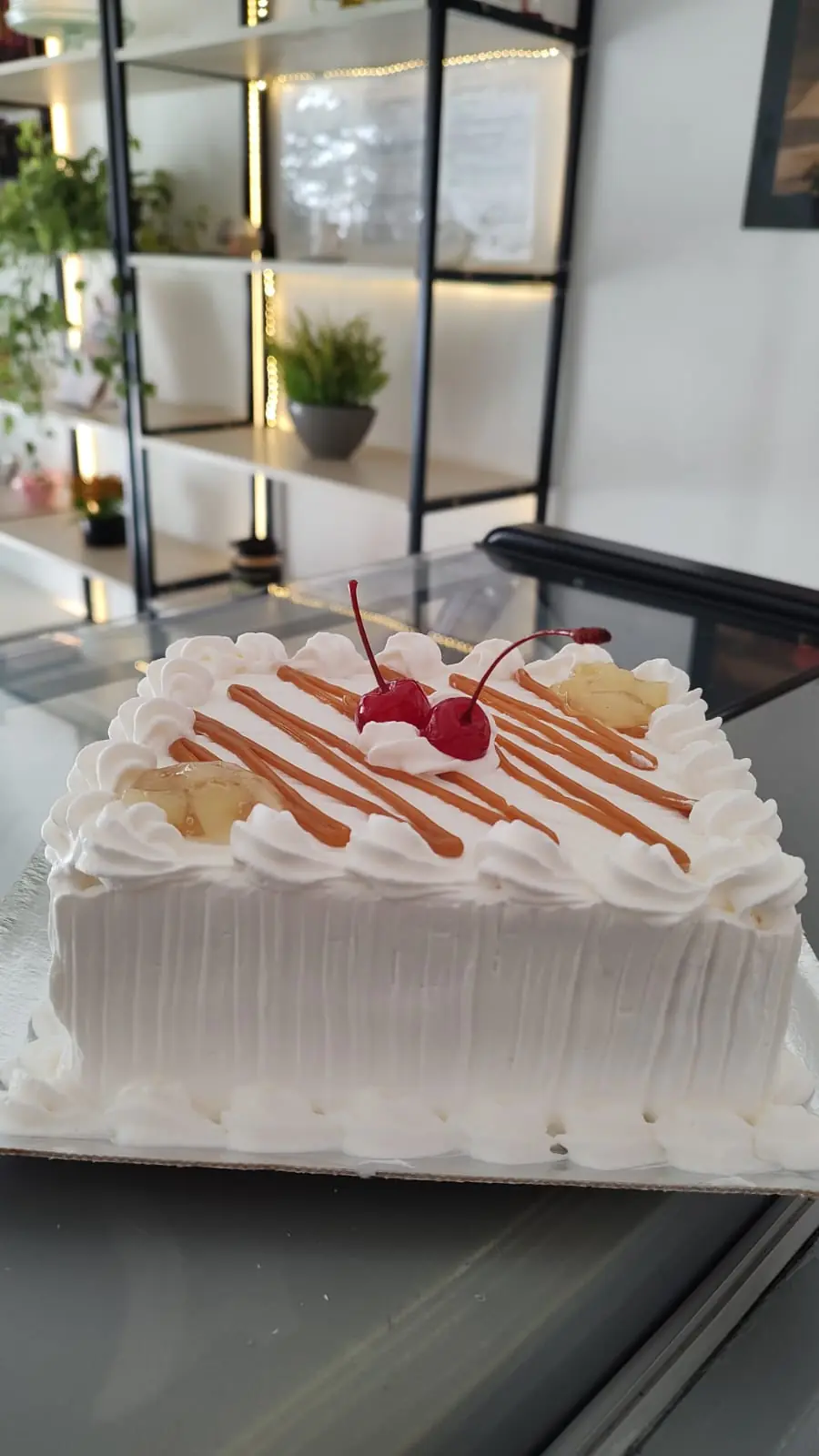 Bolo branco com fios de doce de leite e cerejas