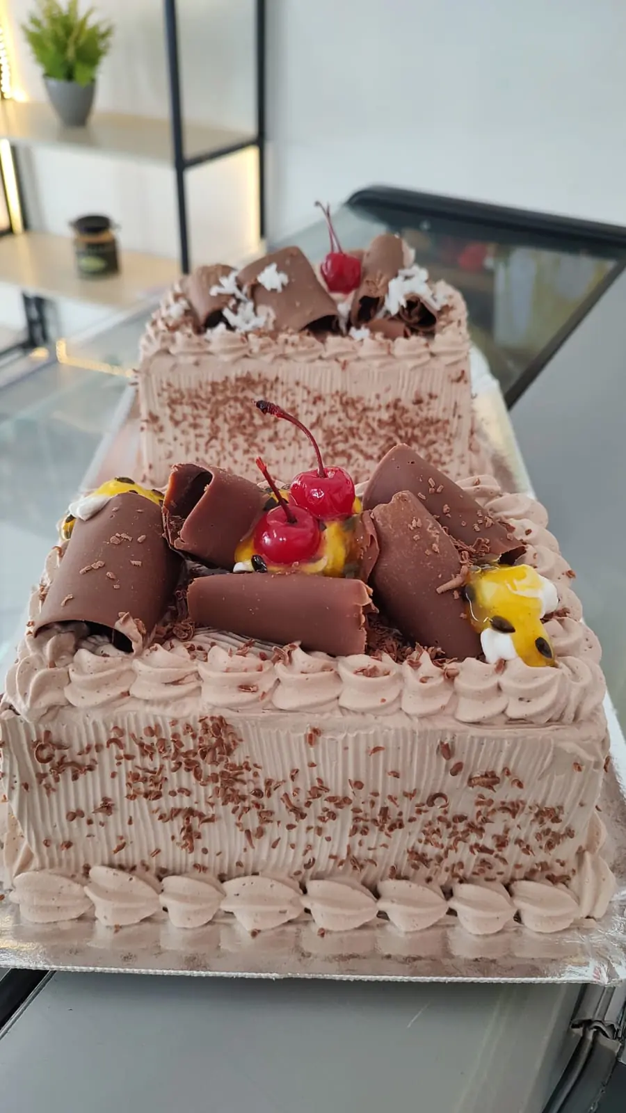 Bolo de chocolate com rolinhos de chocolate, cereja e maracujá